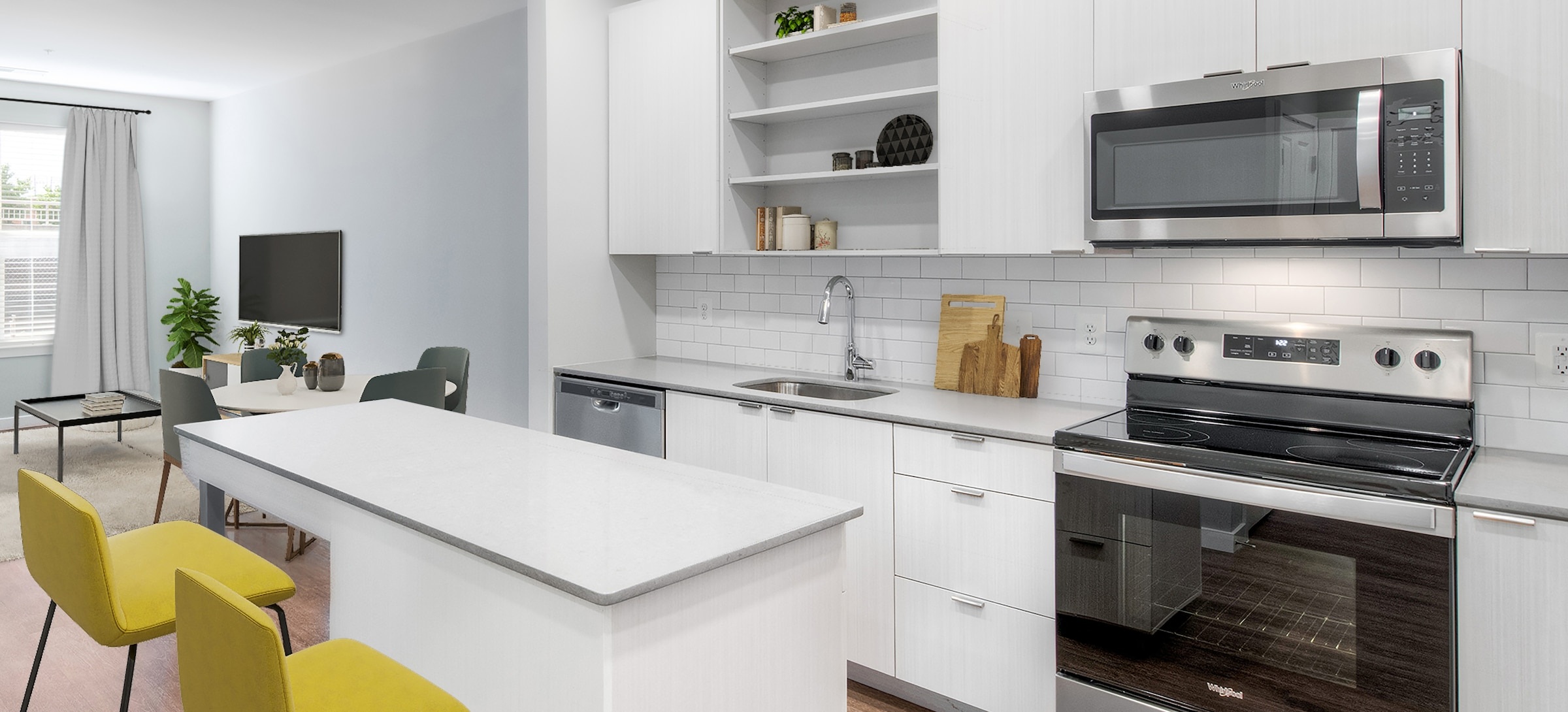 A Kanso apartment kitchen with white cabinets, stainless steel appliances and yellow counter stools