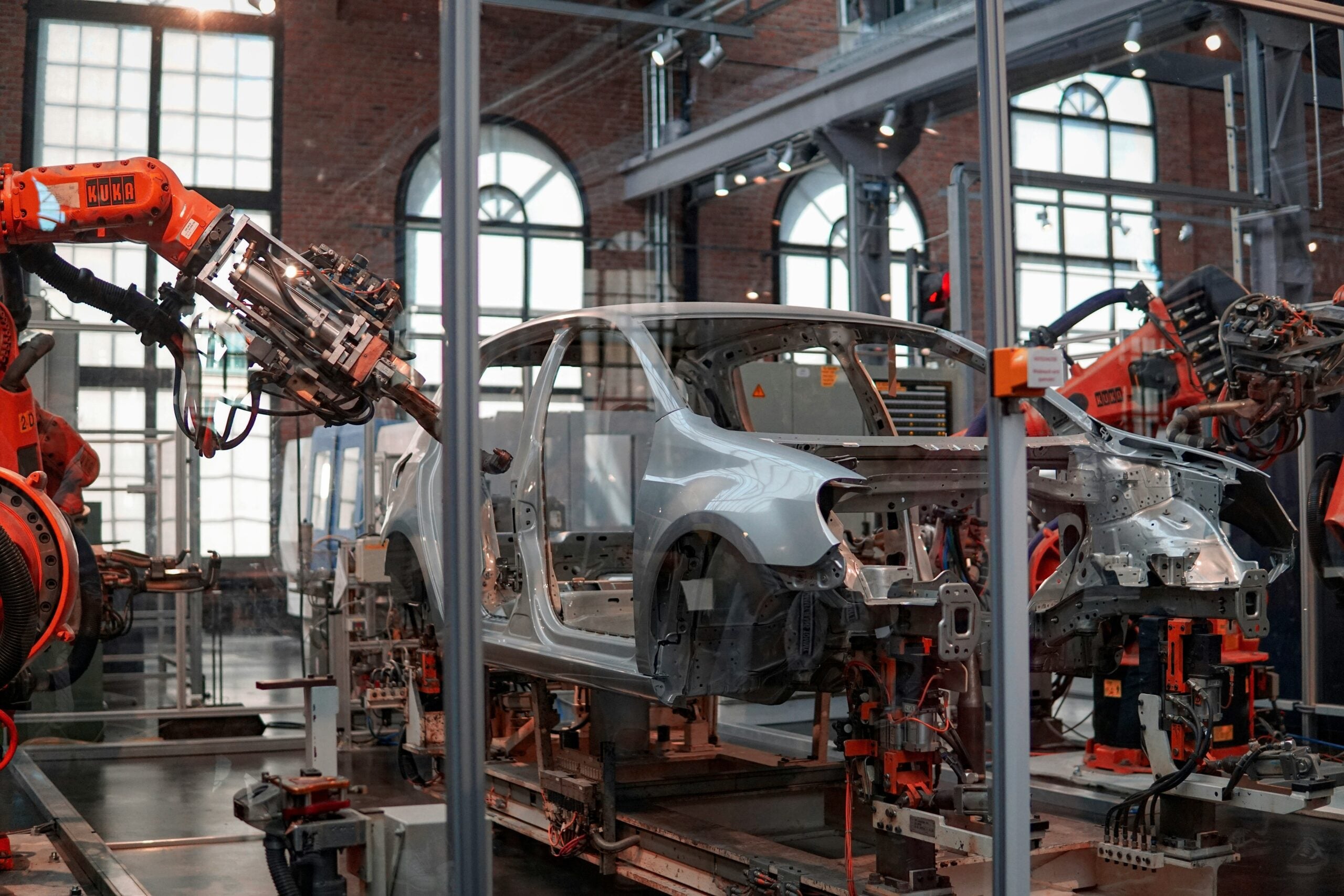 Robotic arms working around a car body in a manufacturing plant