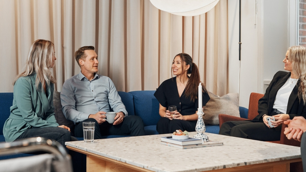 Four Avensia colleagues talking in a company lounge