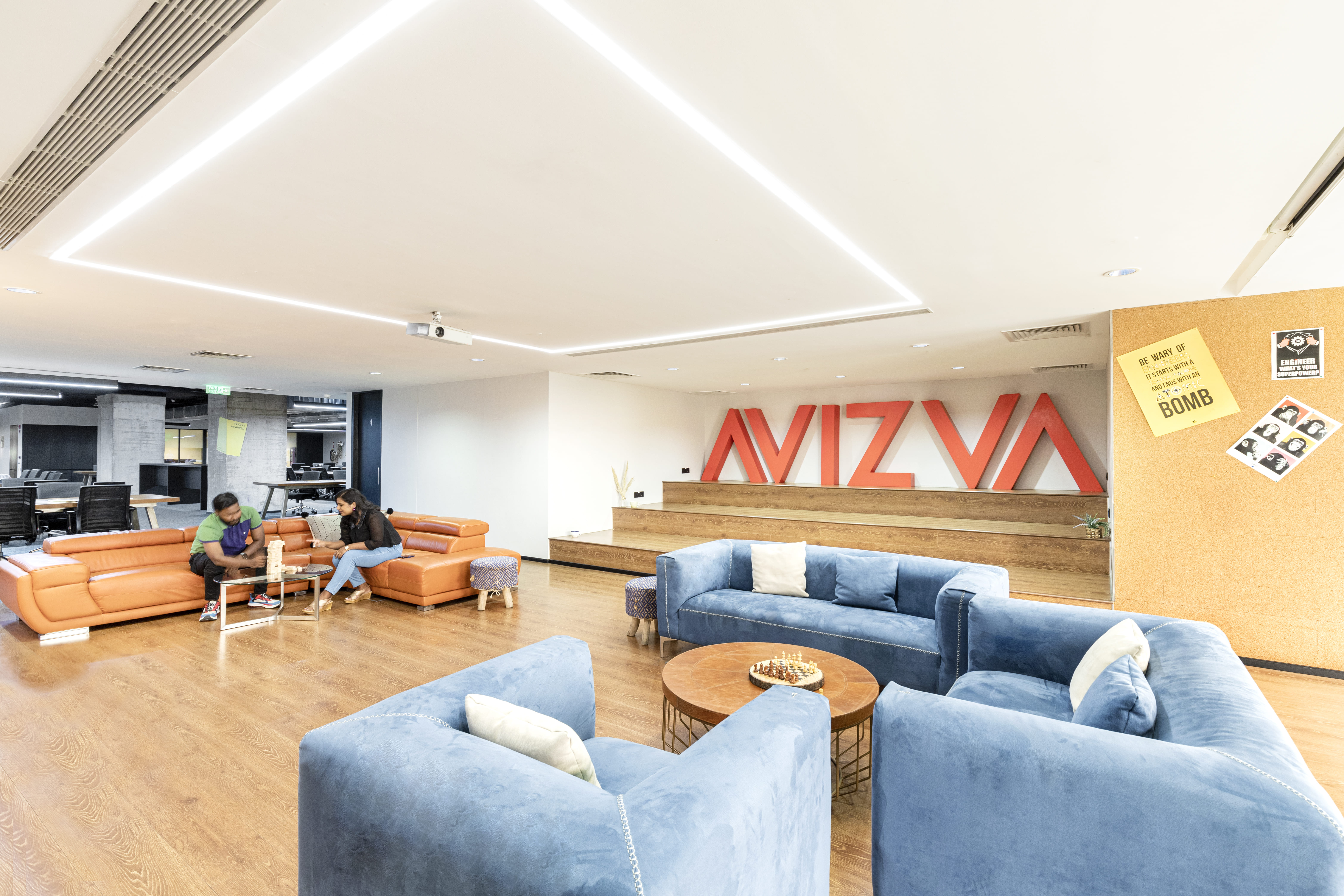 AVIZVA office lounge with blue and orange seating and the company name on the wall