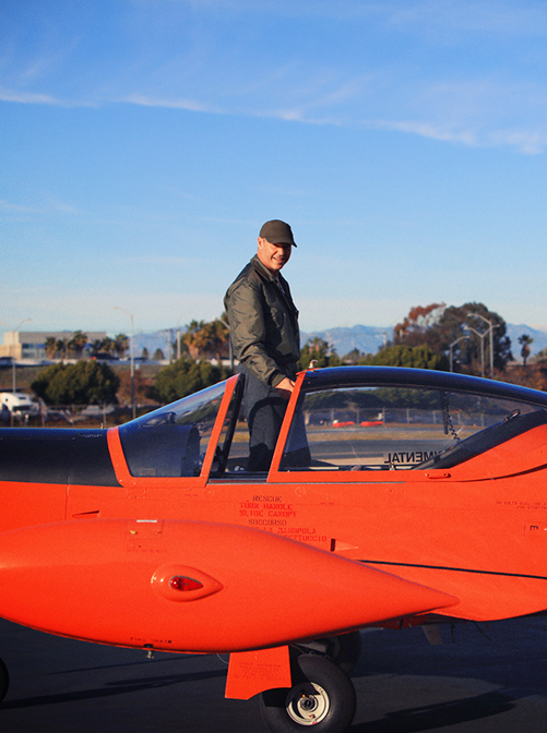 Avner Papouchado standing in an orange aircraft’s open cockpit