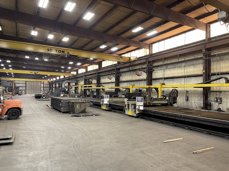 AXH factory floor with plate-processing machinery and overhead cranes