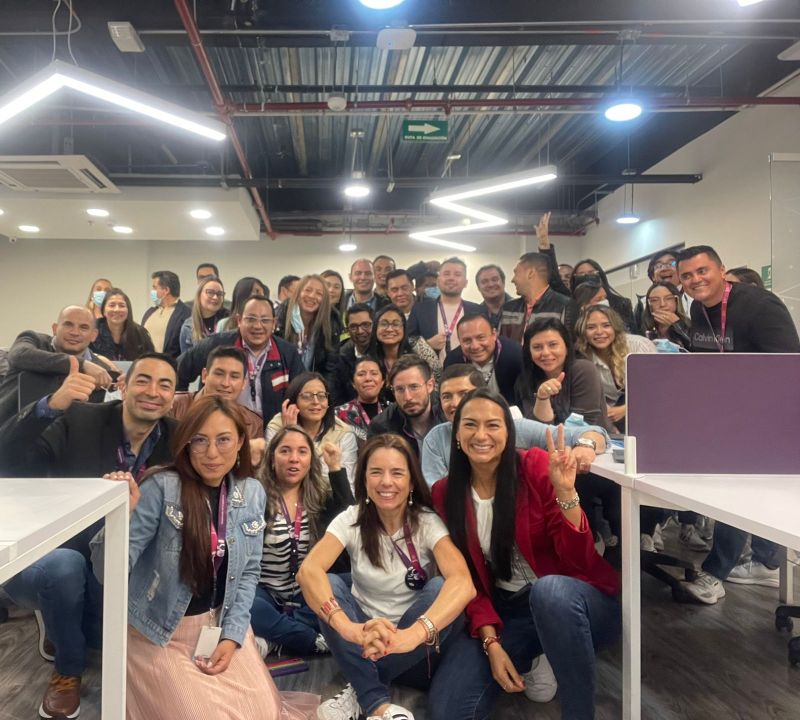 Axity Colombia colleagues gathered in their office in a company photograph posted in 2022