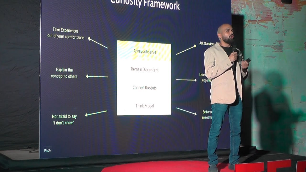 Ayush Jain speaking at TEDxVIIT beside a slide titled Curiosity Framework