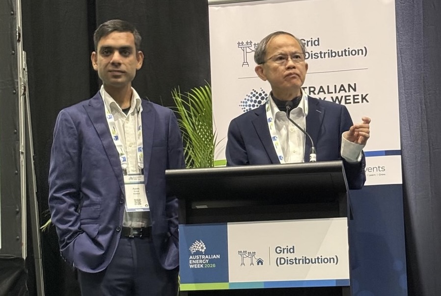 Ayush Sinhal on the left and Dave Lee speaking at a lectern at Australian Energy Week