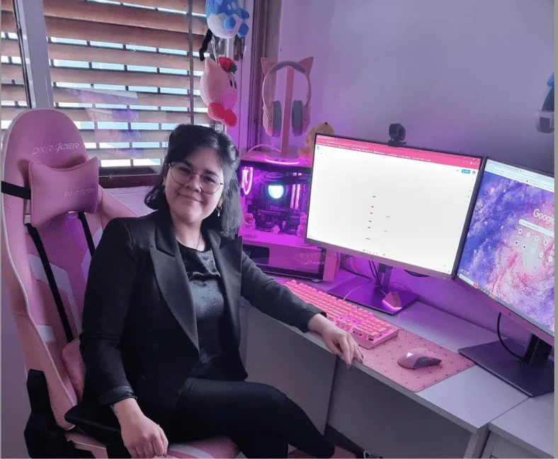 Remote-work setup shown on Azumo’s company page, with dual monitors and a pink chair