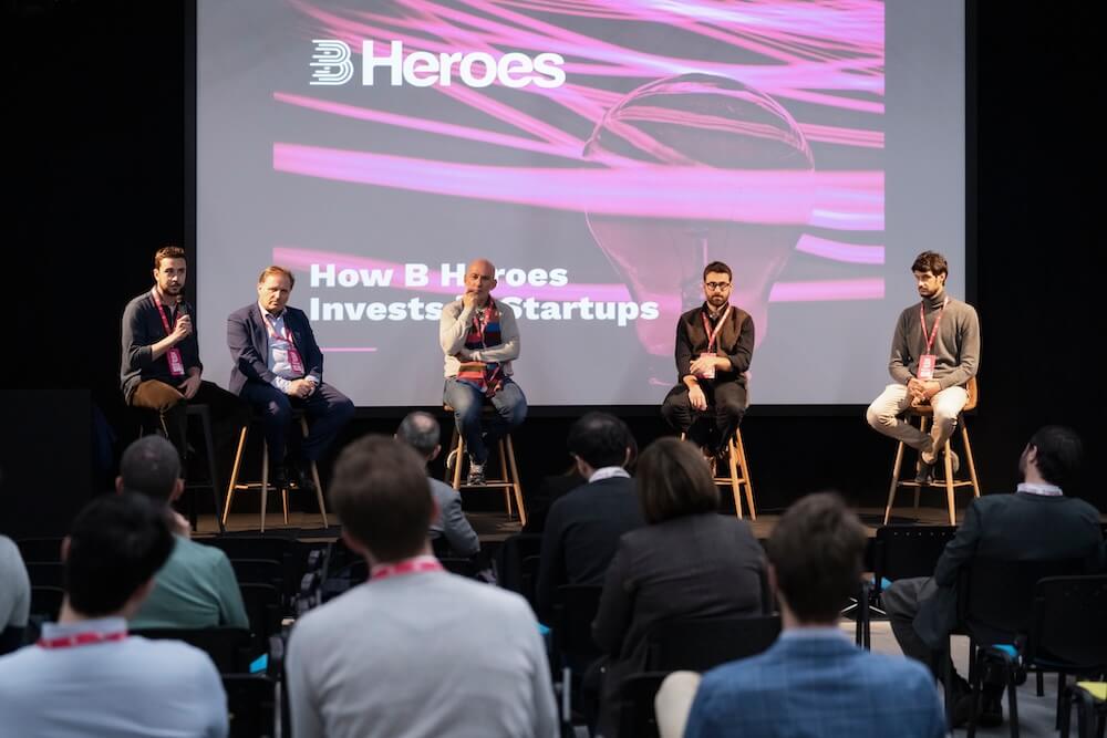 Five speakers discussing B Heroes startup investments before an audience