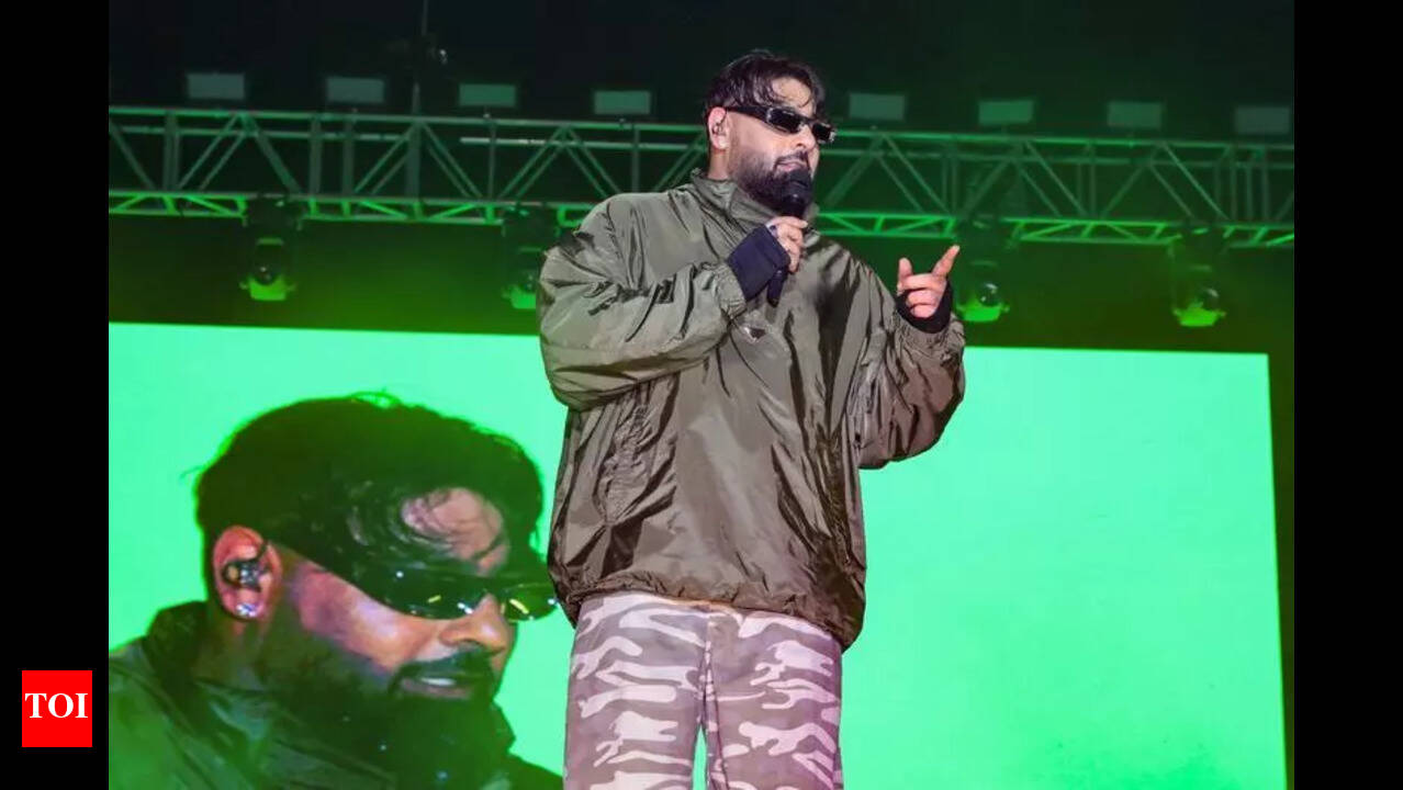 Badshah performing onstage under green concert lights