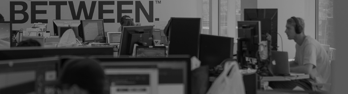 Bailey Lauerman employees working in the Omaha office beneath an Everything In-Between wall graphic