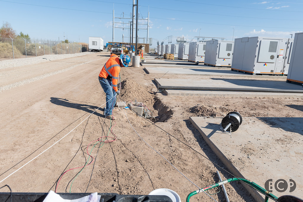 An electrical worker handles wiring beside battery equipment at the LeConte construction site in Calexico.