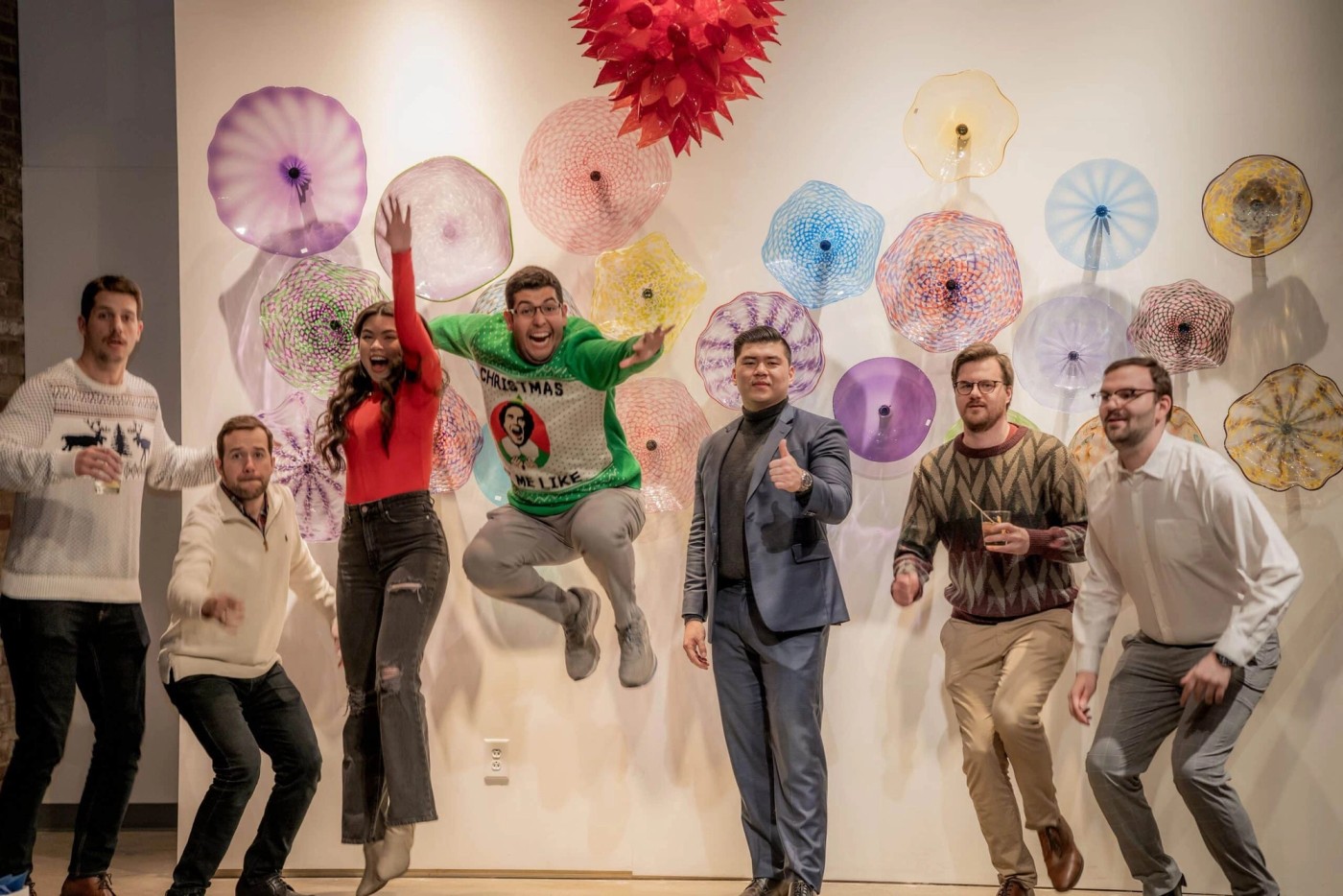 Members of the Balto team posing in front of colorful glass artwork