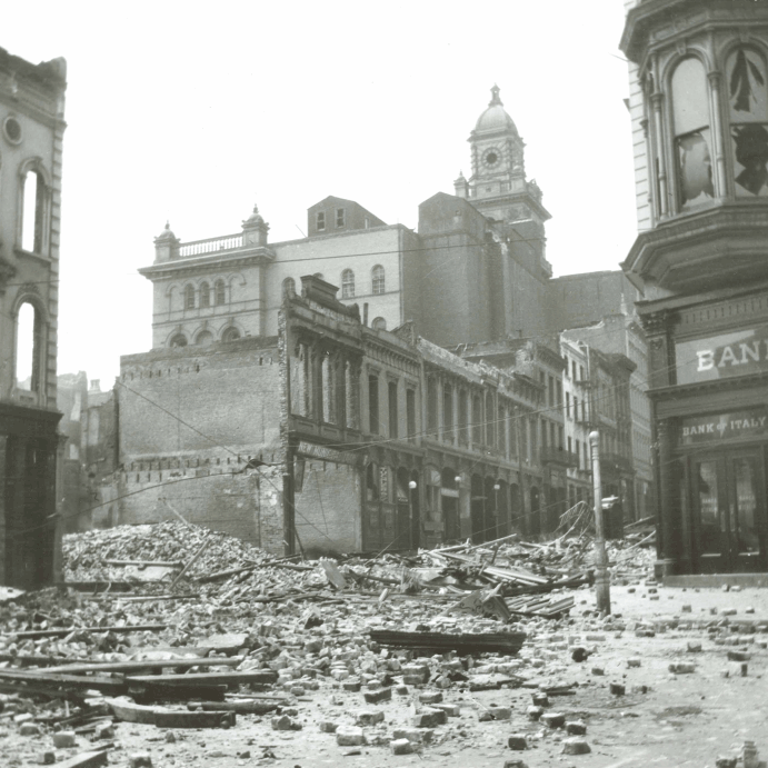 Archival view of damaged San Francisco buildings after the 1906 earthquake, with Bank of Italy signage at right
