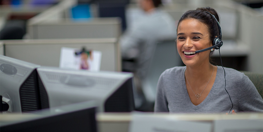 A headset-wearing customer service representative at a computer, in Bank of America’s EricaAssist announcement