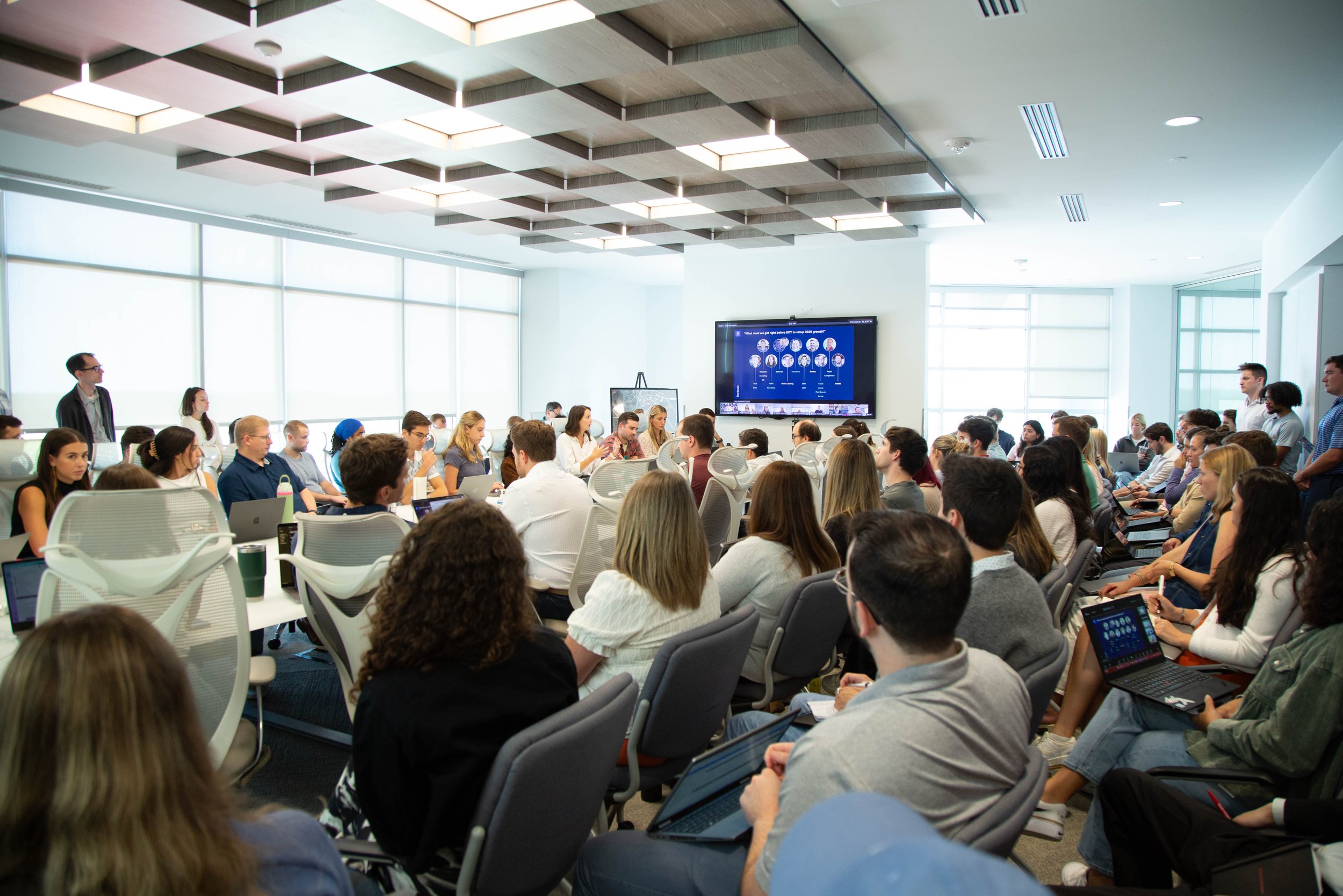 A crowded meeting room in the photograph featured on Red Ventures’ Bankrate portfolio page