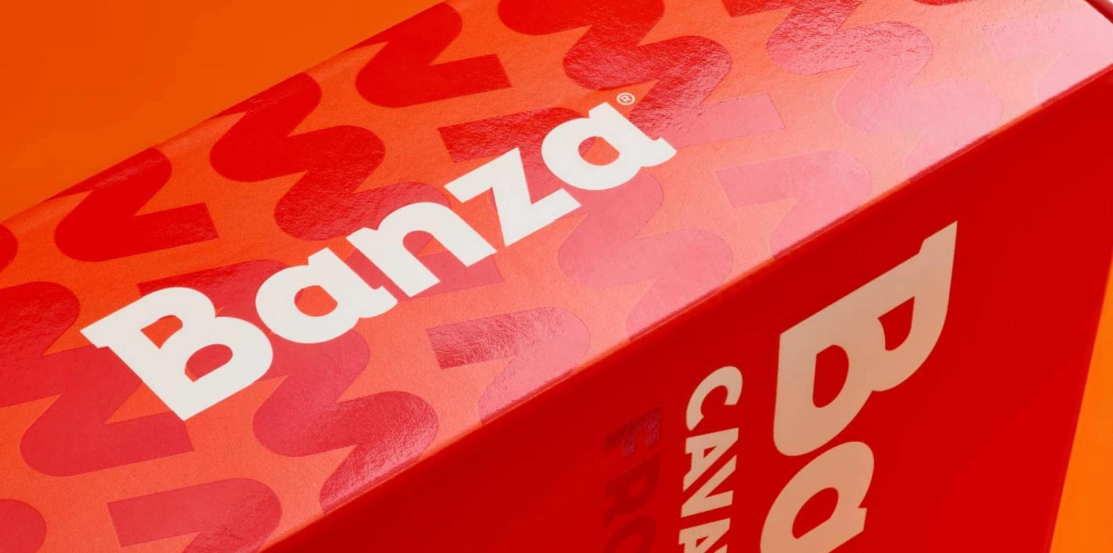 Banza chickpea pasta packaging photographed against an orange background