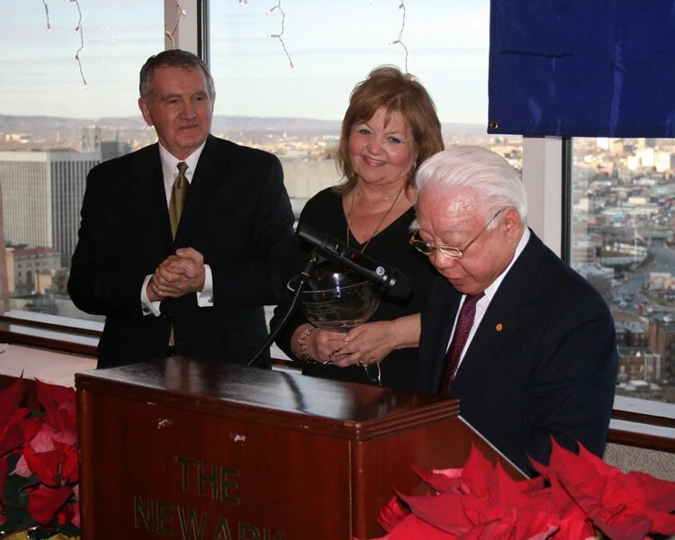 Barbara Spector Yeninas holding an award beside Captain S. Y. Kuo, with Joseph Cervenak looking on.