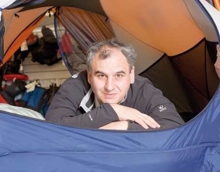 Carlos Barrabés leaning out of a camping tent