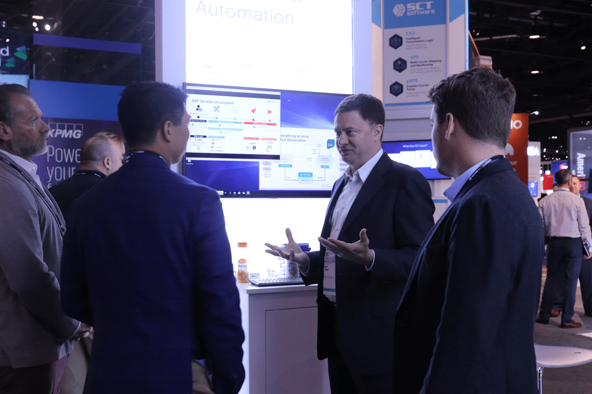 People discussing SAP automation at an exhibition stand, from Basis Technologies’ careers gallery