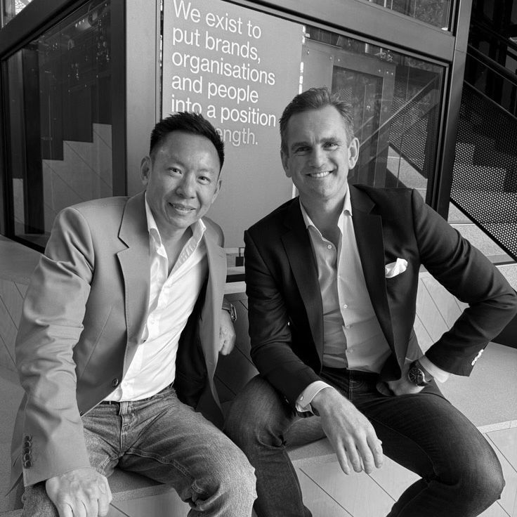 Jack Watts and Cheuk Chiang standing in Bastion's office beneath the company's mission statement