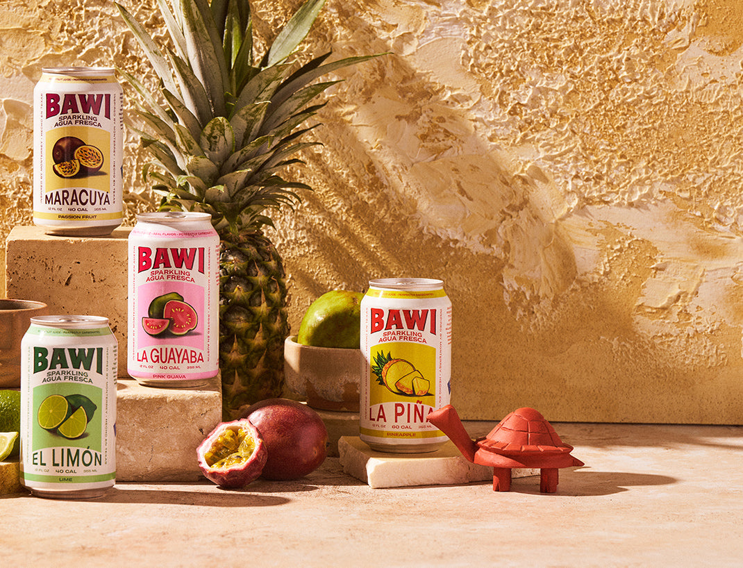 Bawi cans photographed beside a pineapple