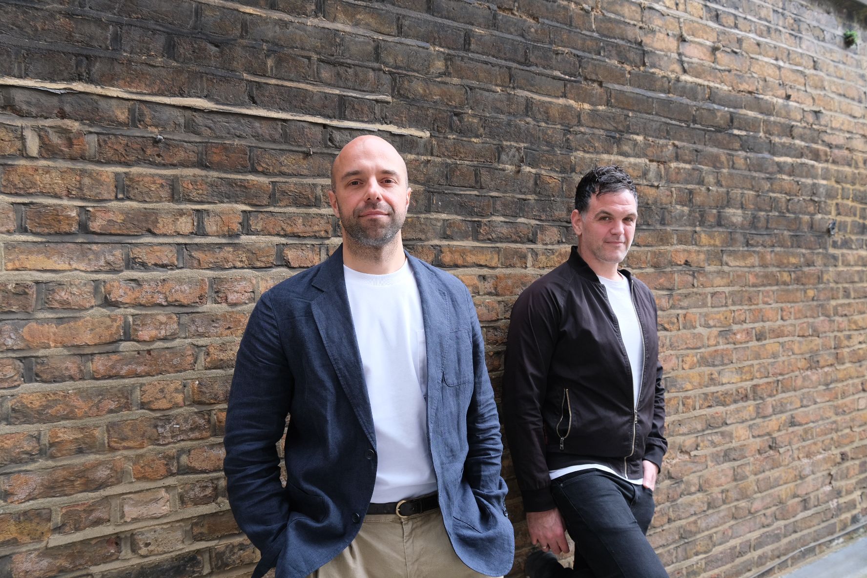 BeatpulseLabs co-founders photographed beside a brick wall