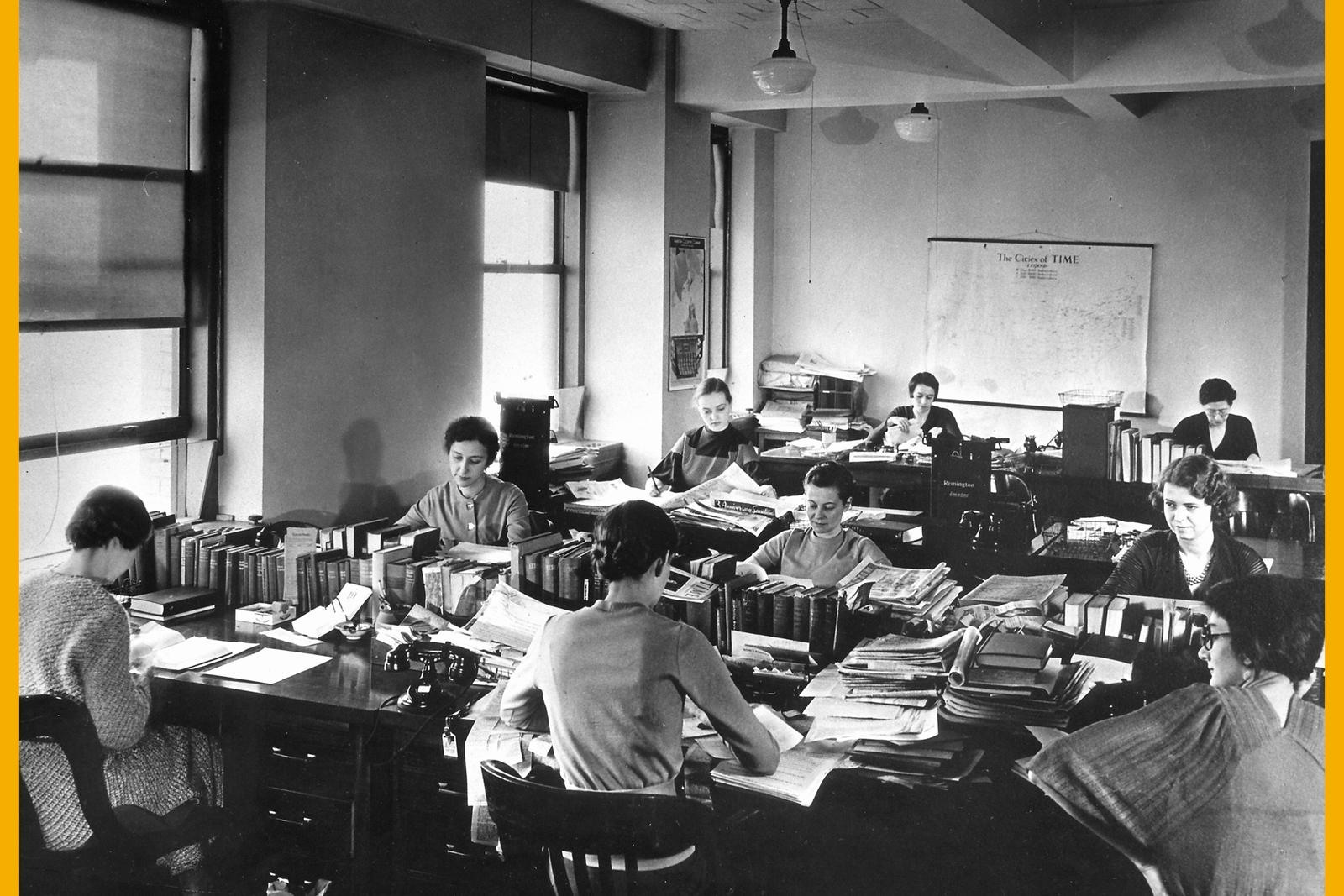 TIME editorial staff working around a table with books and typewriters in 1933