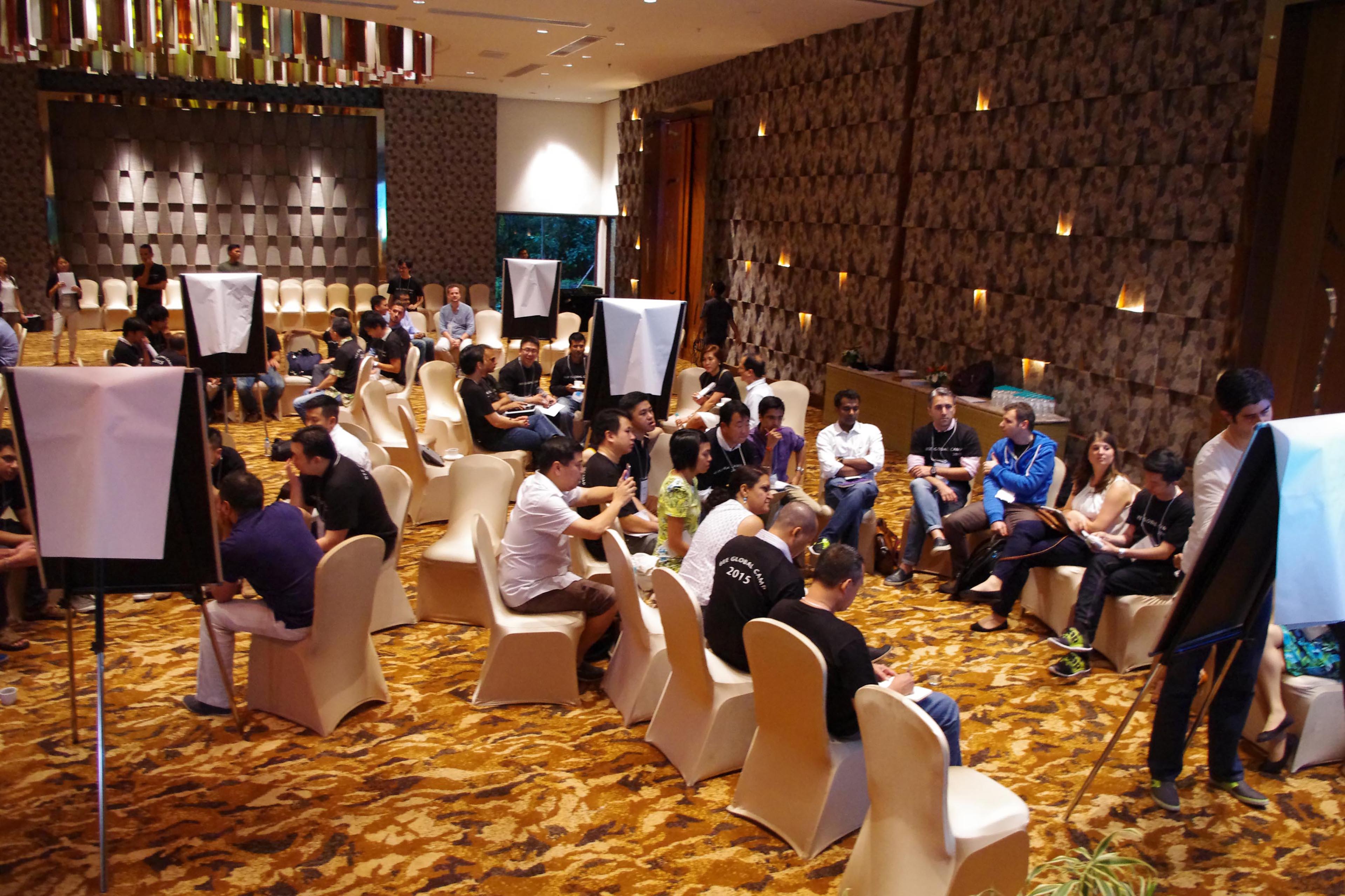 Founders seated in small discussion groups at a BEE Global Camp gathering