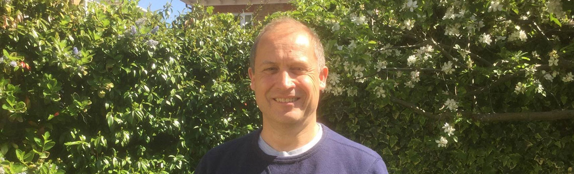 Giles Jepson outdoors in front of green foliage