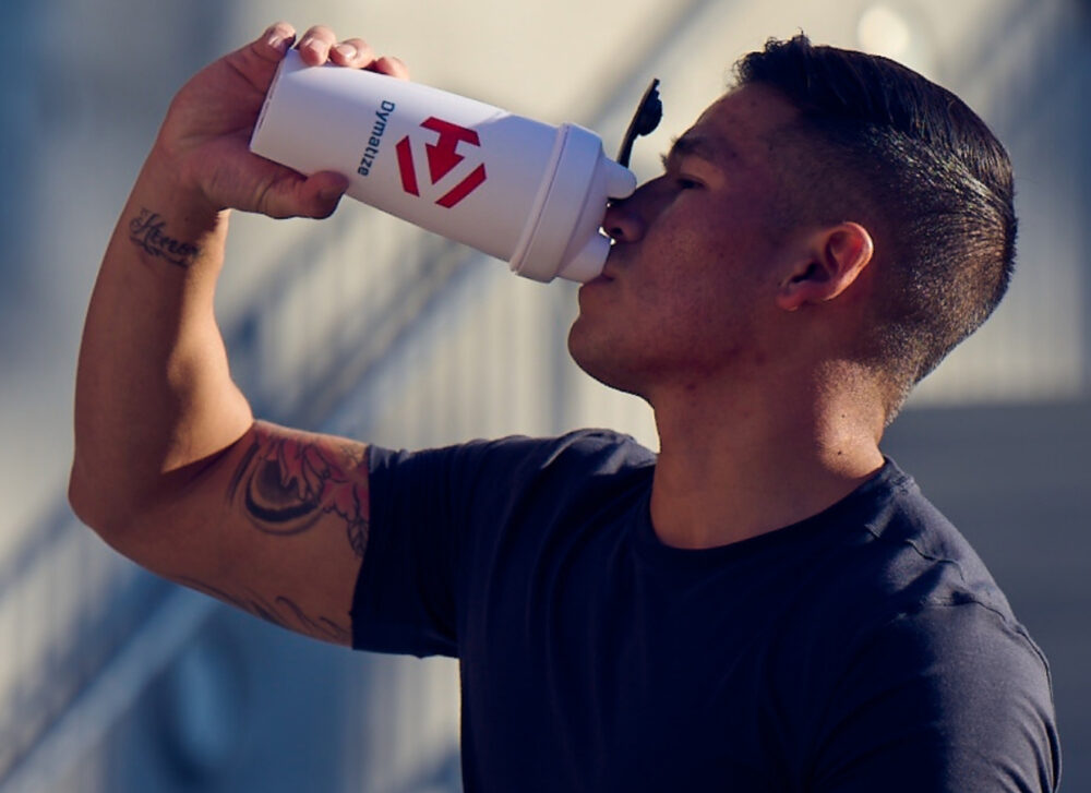 A man drinking a Dymatize protein shake