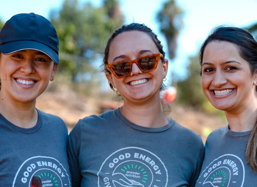 Three Premier Nutrition employees volunteering in a garden