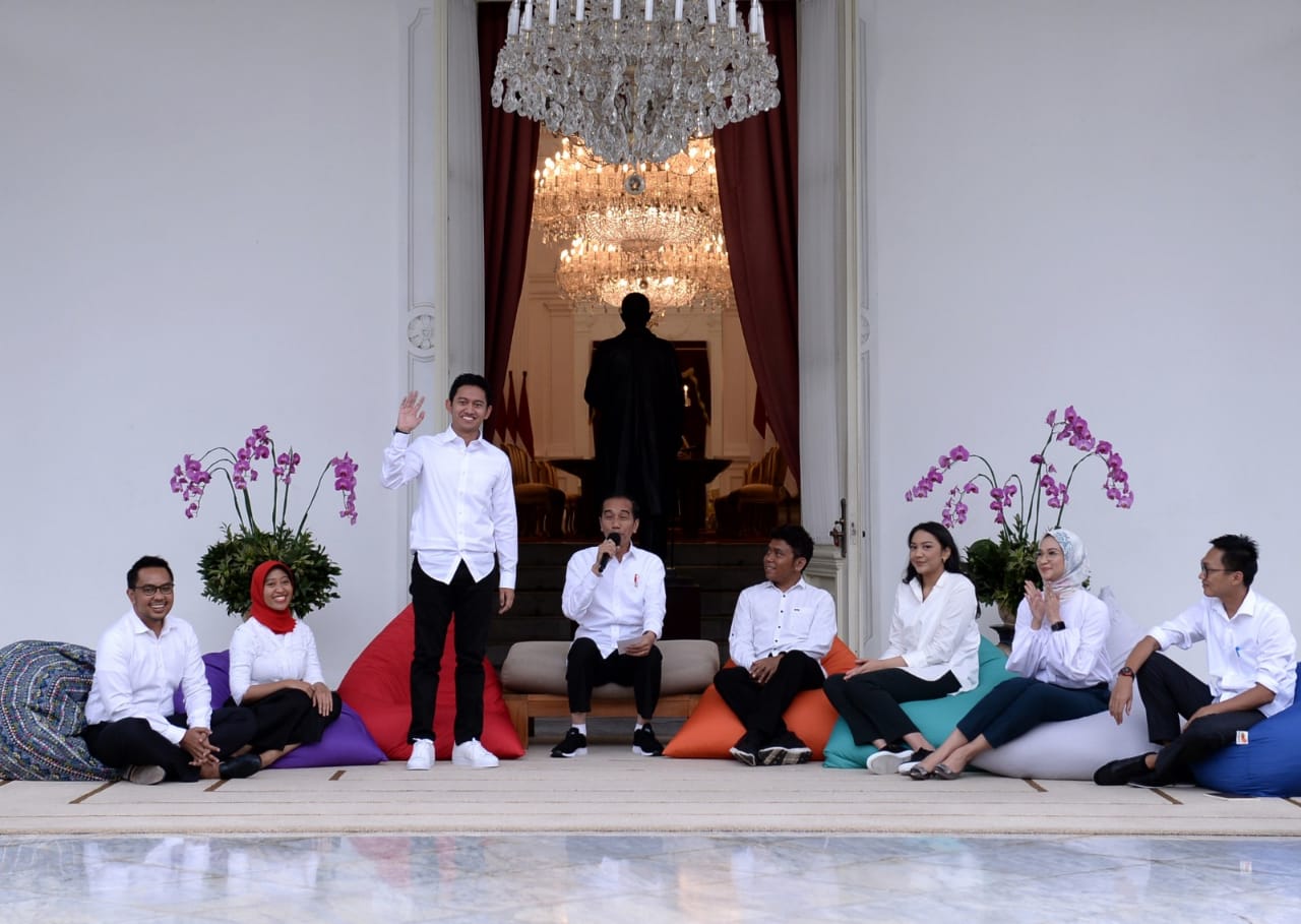Belva Devara standing and waving beside President Joko Widodo and fellow presidential special staff members in November 2019.