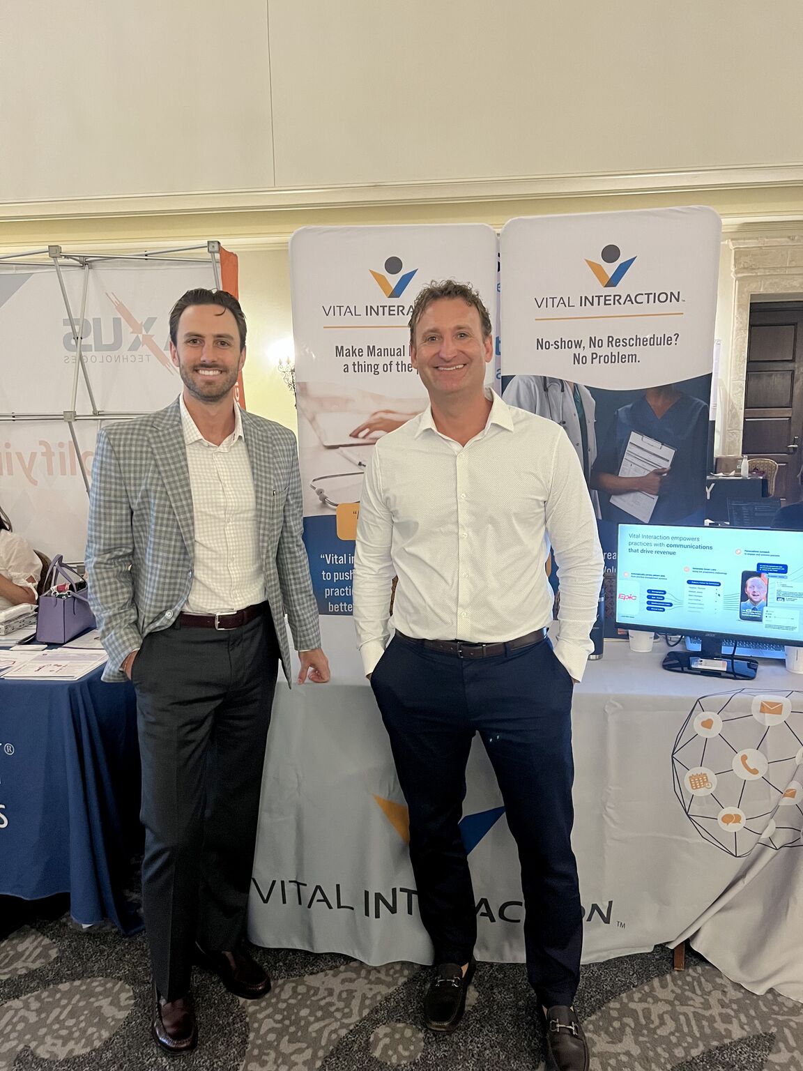 Jacob Moore and Ben Chapman standing at the Vital Interaction booth during the Waves of Change Educational Conference