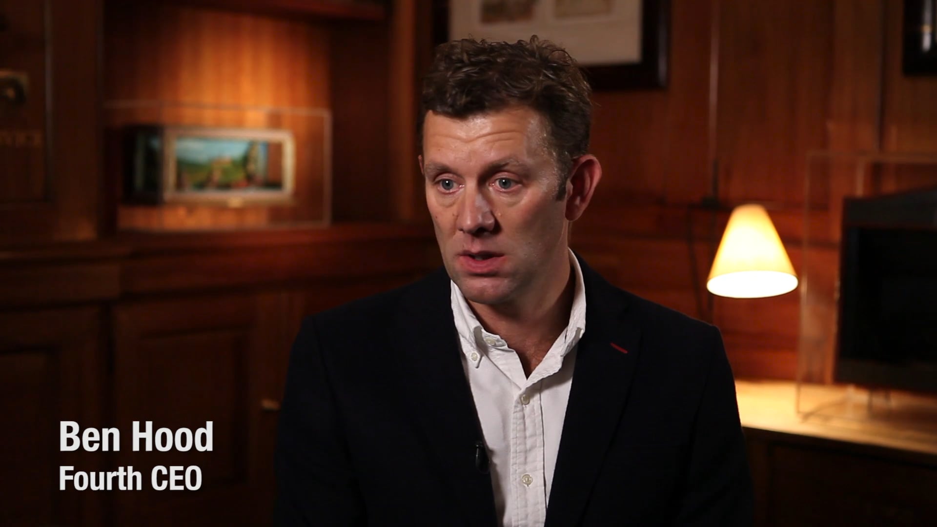 Ben Hood speaking during an ECI Partners interview, wearing a dark jacket in a wood-panelled room