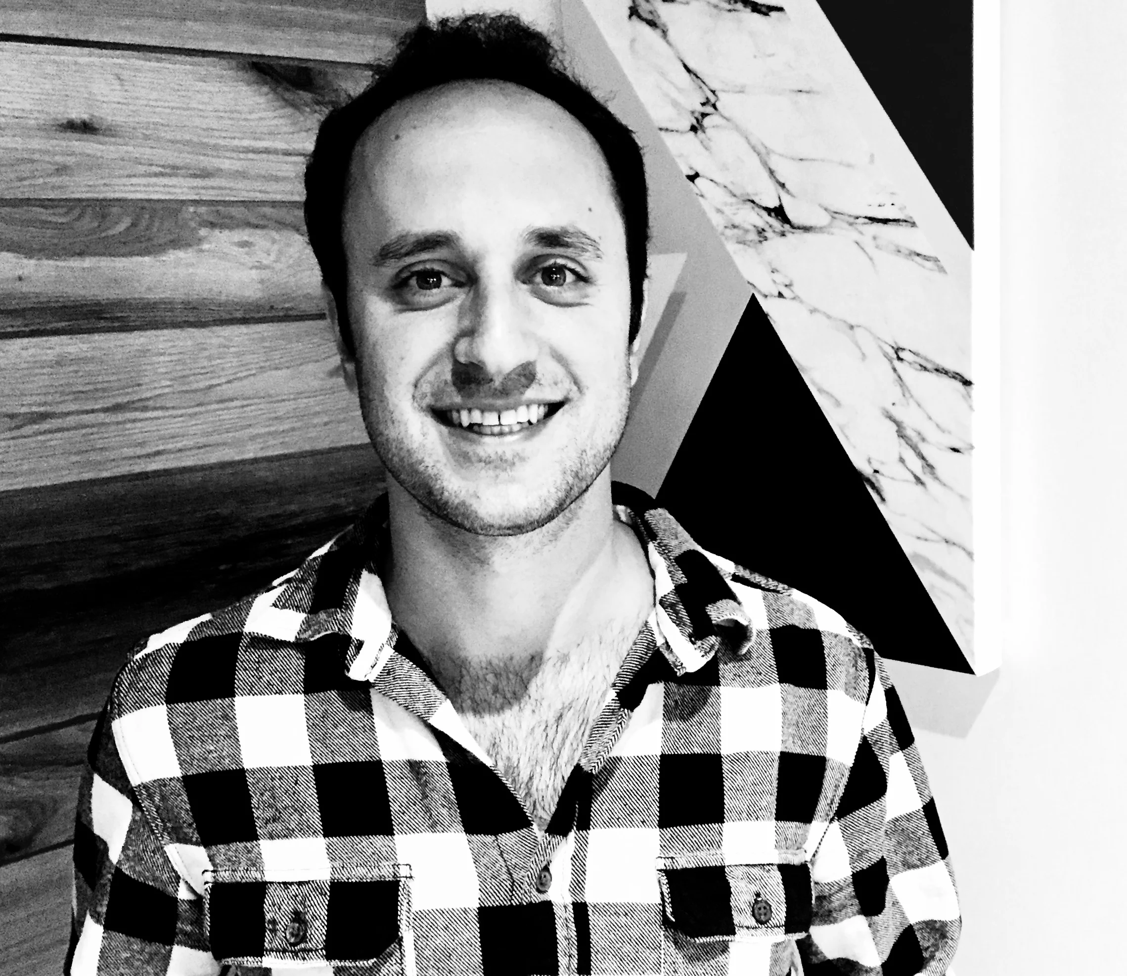 An archival black-and-white photograph of Ben Jabbawy in a checked shirt