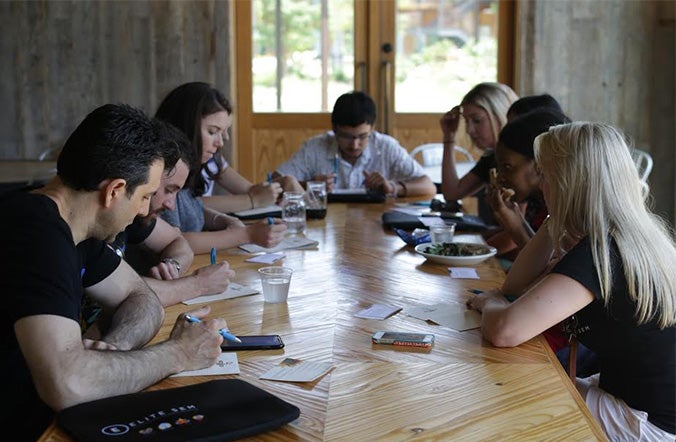 Elite SEM colleagues working around a long wooden table