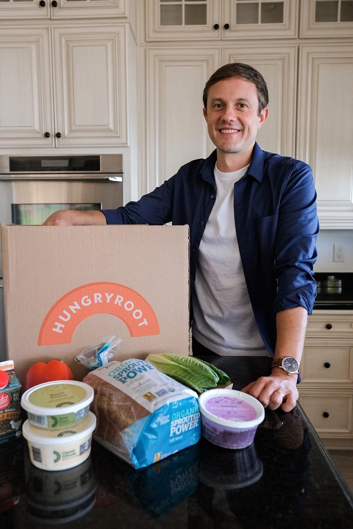 Ben McKean beside a Hungryroot delivery box and groceries on a kitchen counter