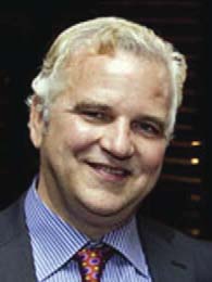 Archival photograph of Ben Merritt in a dark suit and patterned tie, published in May 2012.