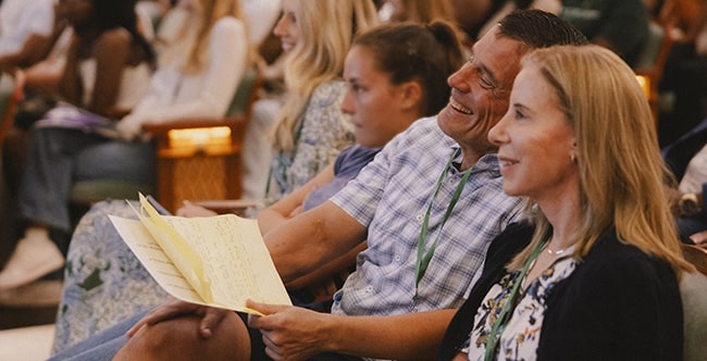 Ben and Kelly Navarro smiling while seated together in an audience