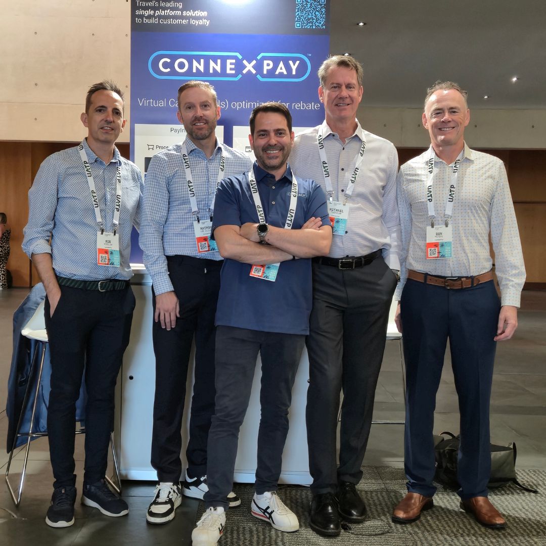 Ben Peters and four ConnexPay colleagues stand at the ConnexPay booth during Phocuswright Europe in Barcelona in 2025