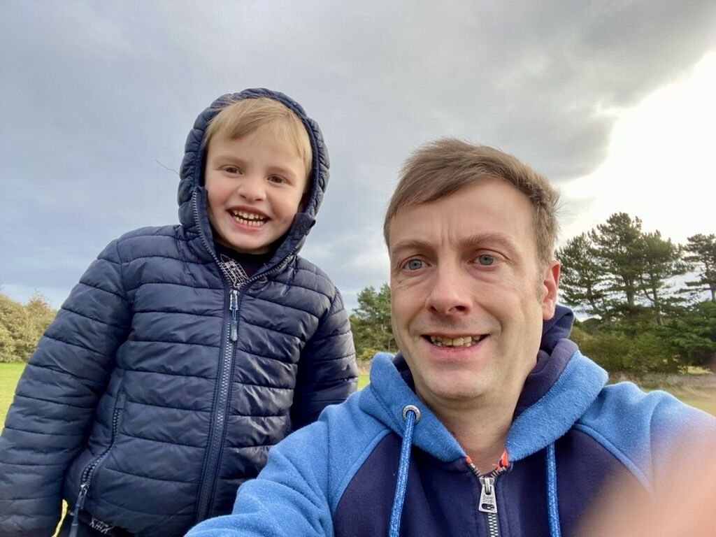 Ben Portsmouth outdoors with his son, both wearing blue jackets