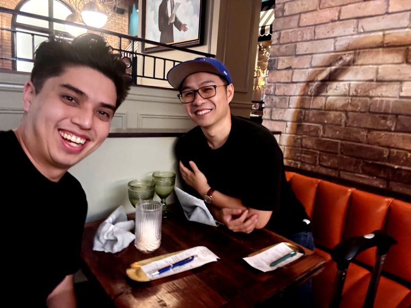 Ben Pugh and Michael Chen smiling together at a restaurant table