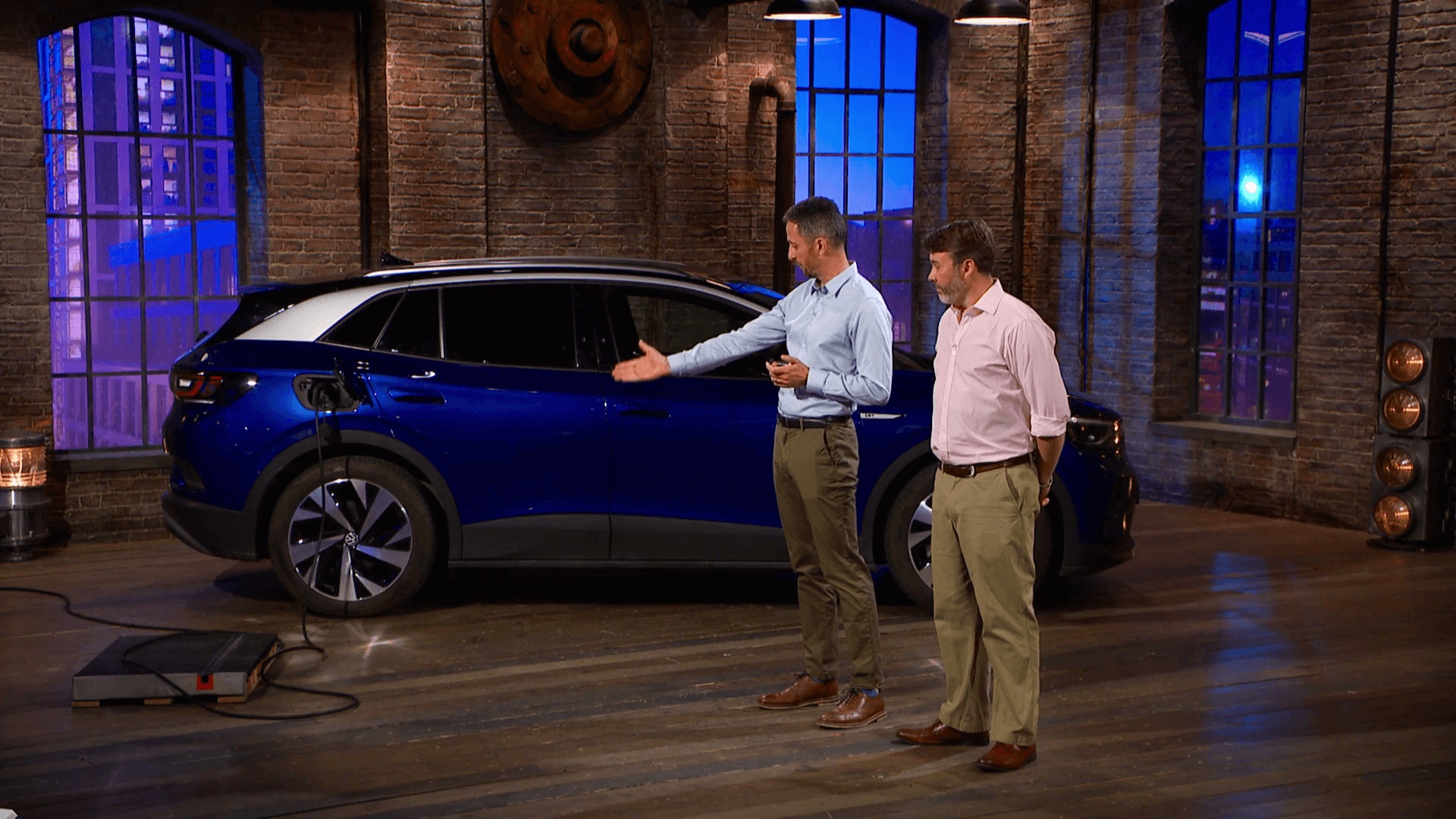 Michael Goulden and Ben Whitaker demonstrating Kerbo Charge beside an electric car on Dragons’ Den