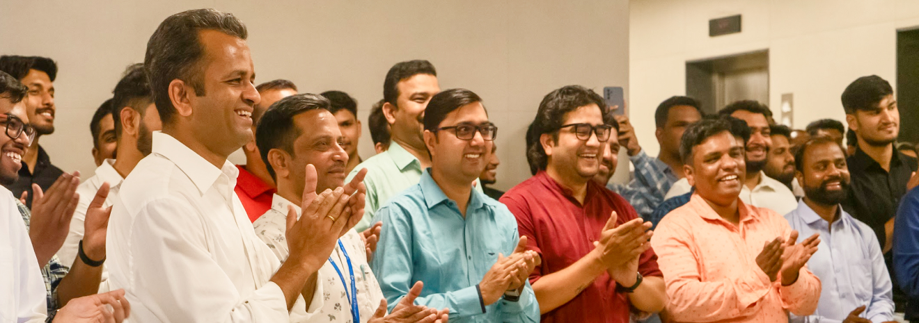 Benchmark staff gathered together, smiling and applauding
