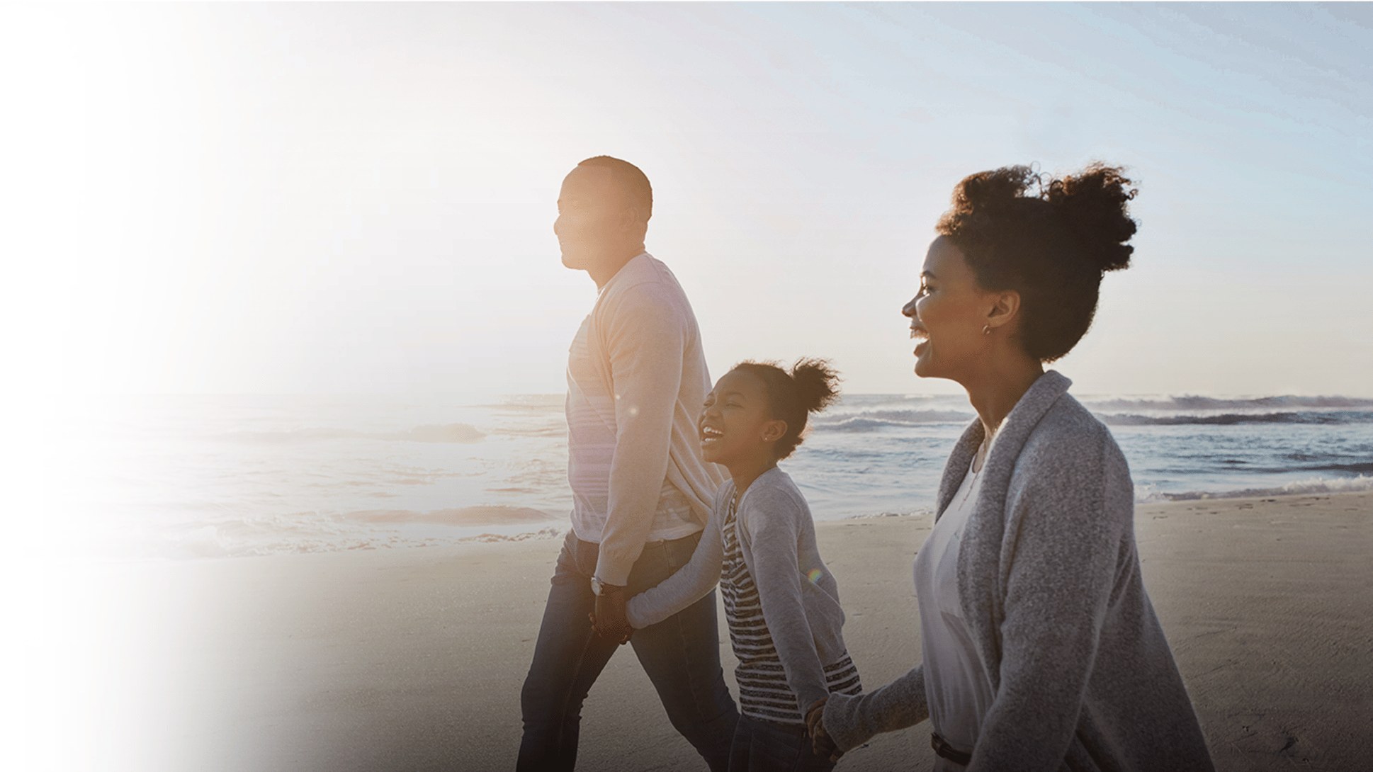 A family walking together on a beach at sunset