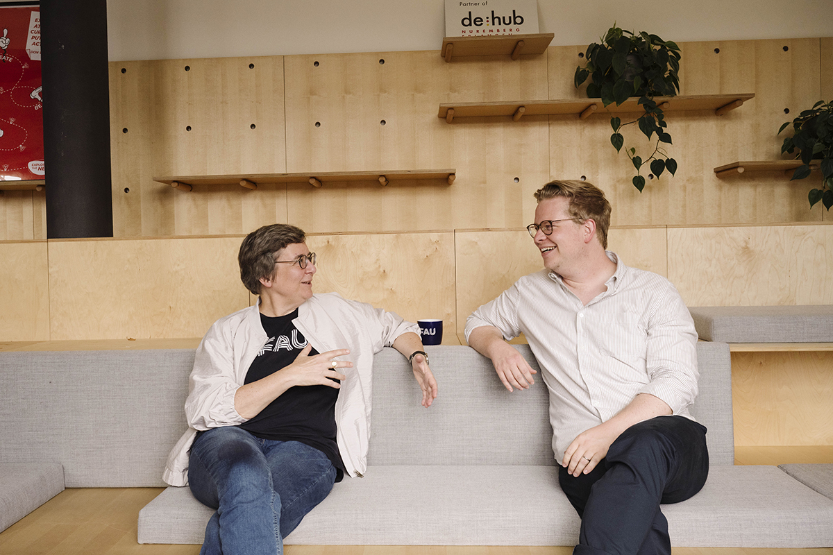 Kathrin Möslein and Benjamin Bauer talking on a sofa at ZOLLHOF