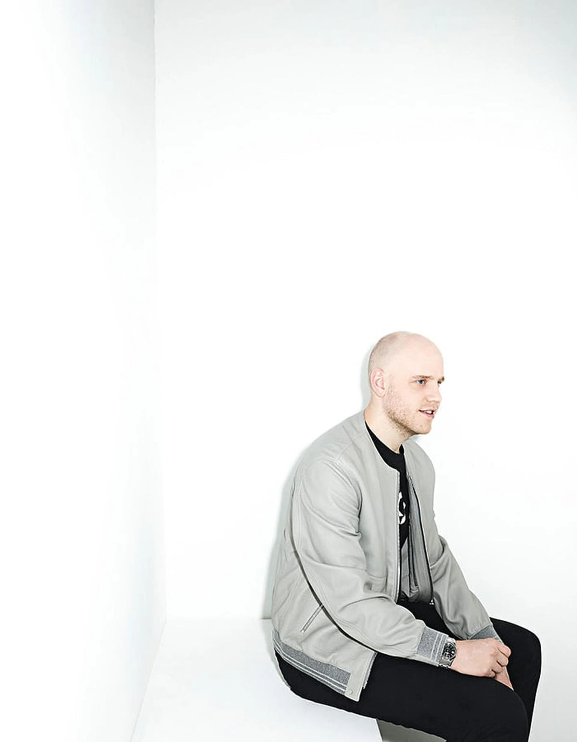 Benjamin Harris seated in a light gray jacket against a white studio background