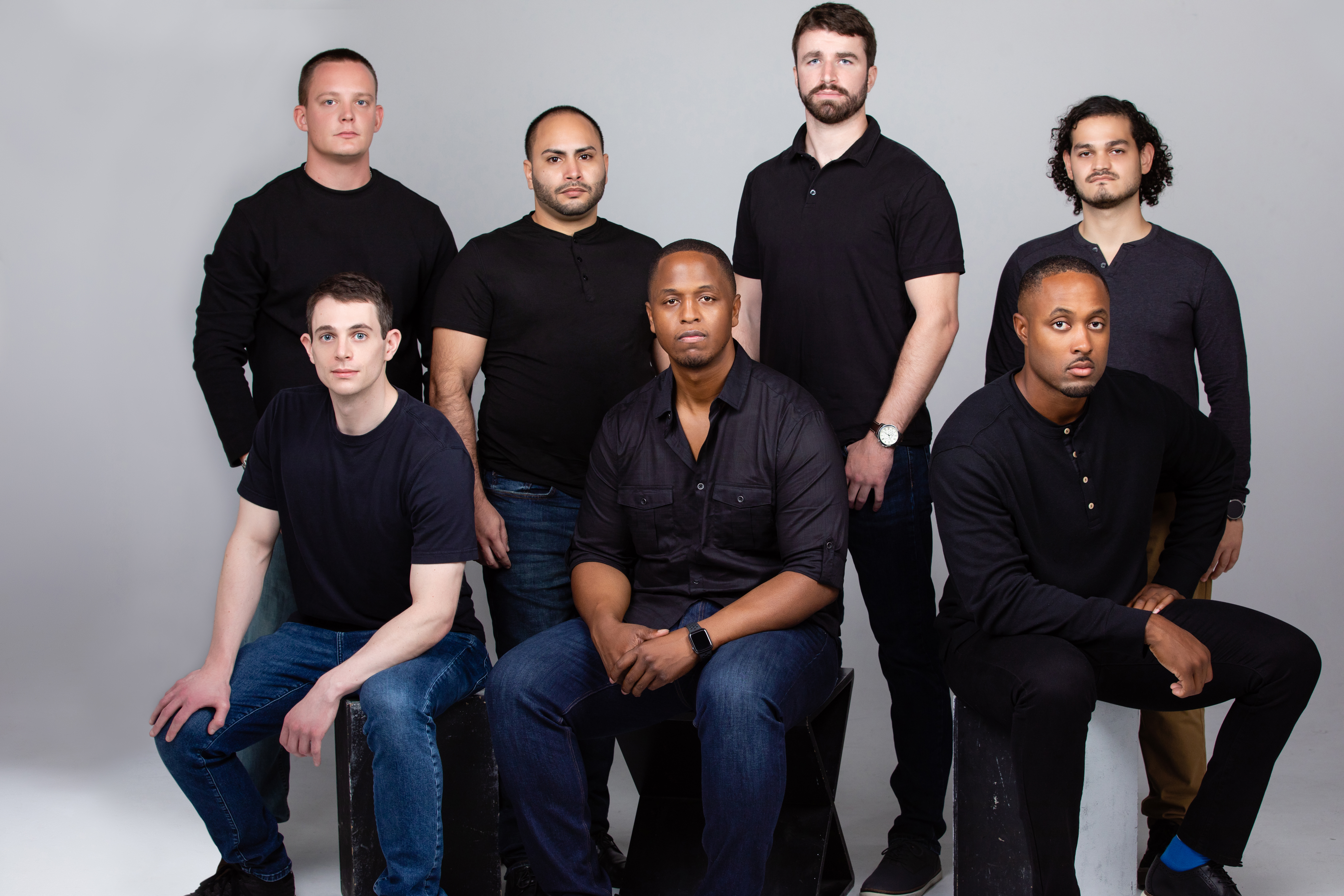 Benjamin Harvey seated in the center of a seven-person AI Squared team photograph