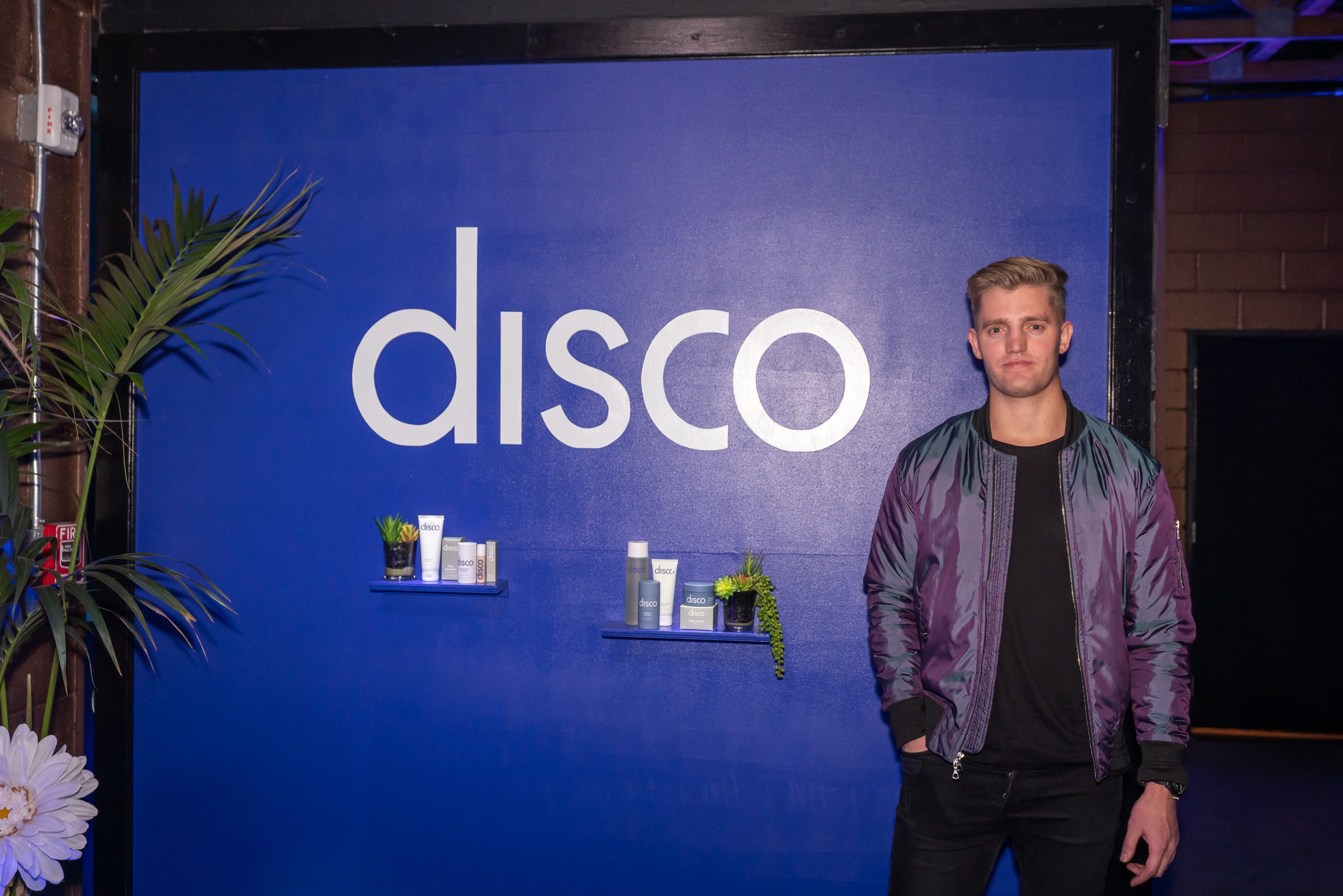 Benjamin Smith standing beside a blue Disco display with products on shelves