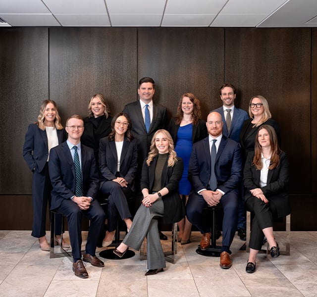 Twelve Bennett Jones partners posed together in a wood-panelled office