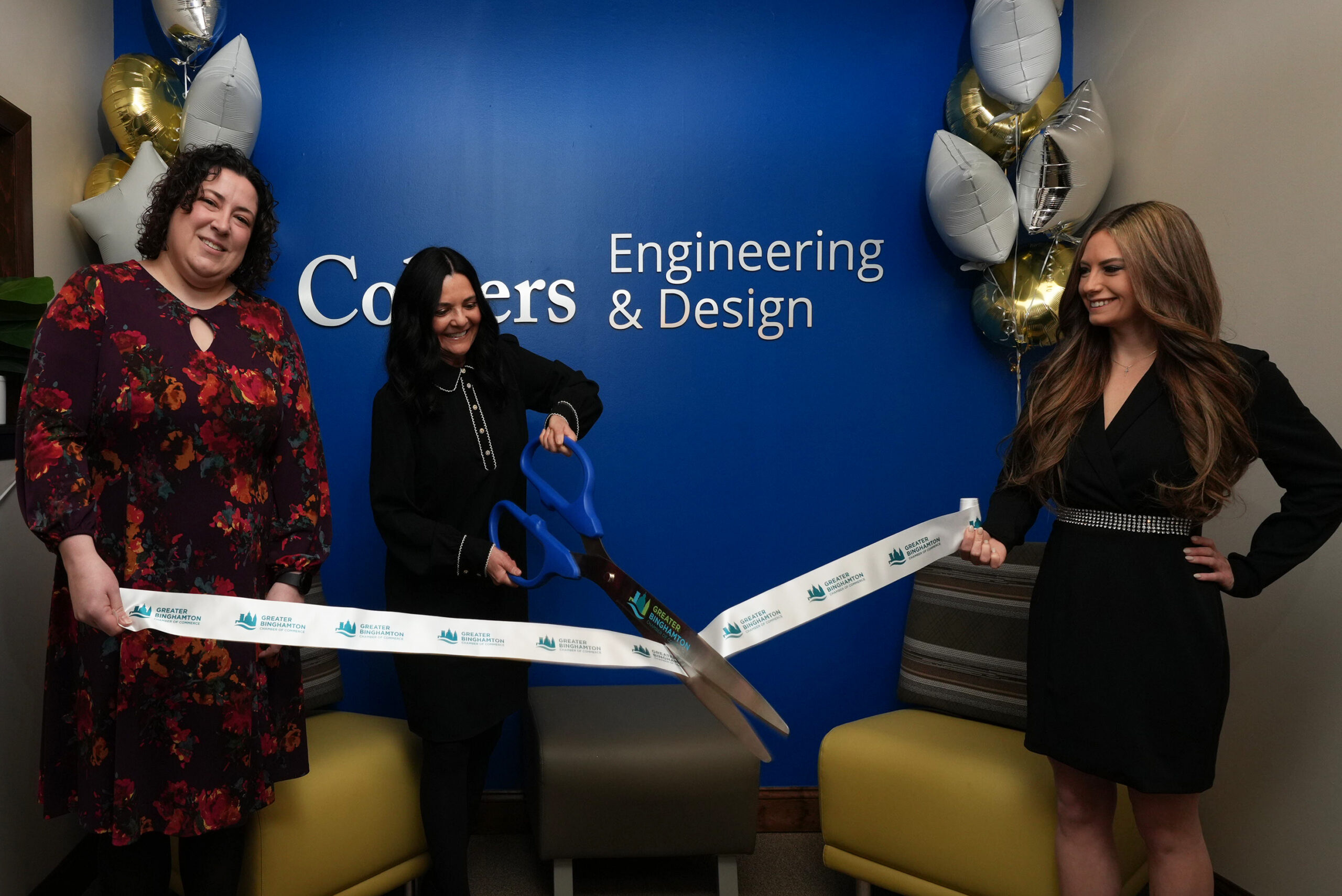 Three participants celebrate the Binghamton office rebrand with a ribbon cutting in front of a Colliers Engineering and Design sign.